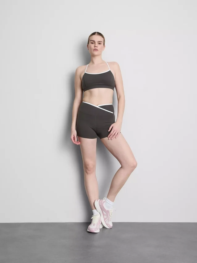 Kontrastně lemovaný sportovní crop top s kříženými ramínky na zádech