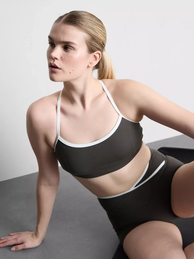 Kontrastně lemovaný sportovní crop top s kříženými ramínky na zádech