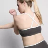 Kontrastně lemovaný sportovní crop top s kříženými ramínky na zádech
