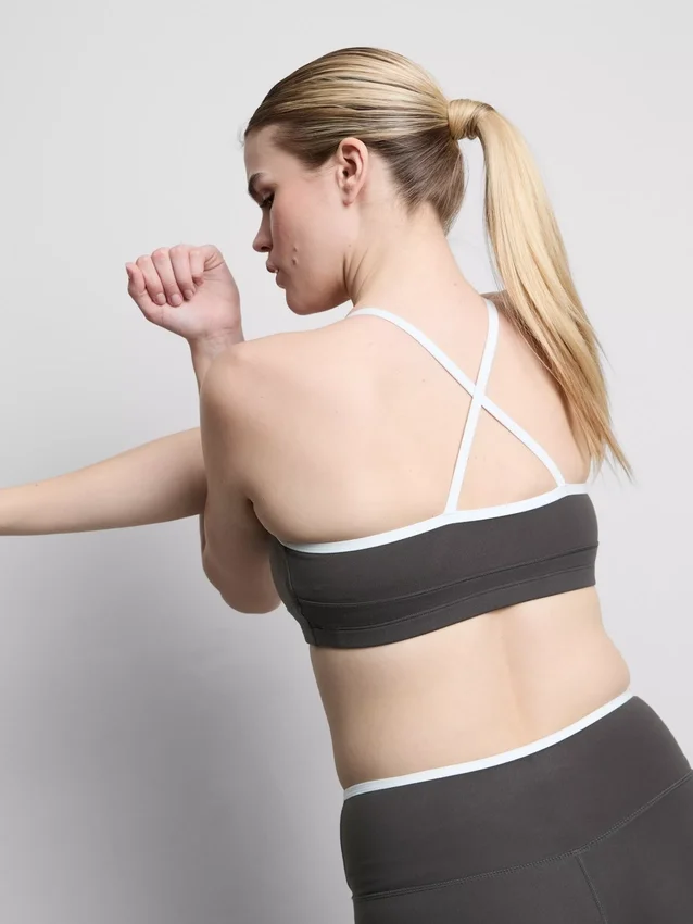 Kontrastně lemovaný sportovní crop top s kříženými ramínky na zádech