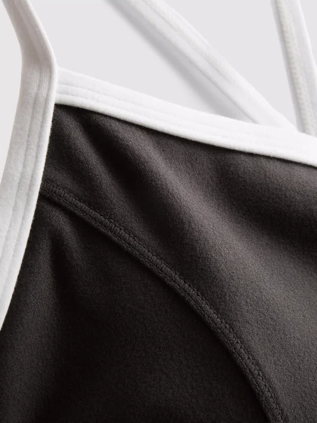 Kontrastně lemovaný sportovní crop top s kříženými ramínky na zádech